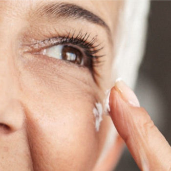 Senior woman applying eye cream